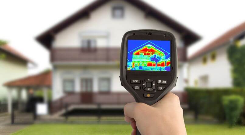 Thermal imaging camera showing heat loss on a house