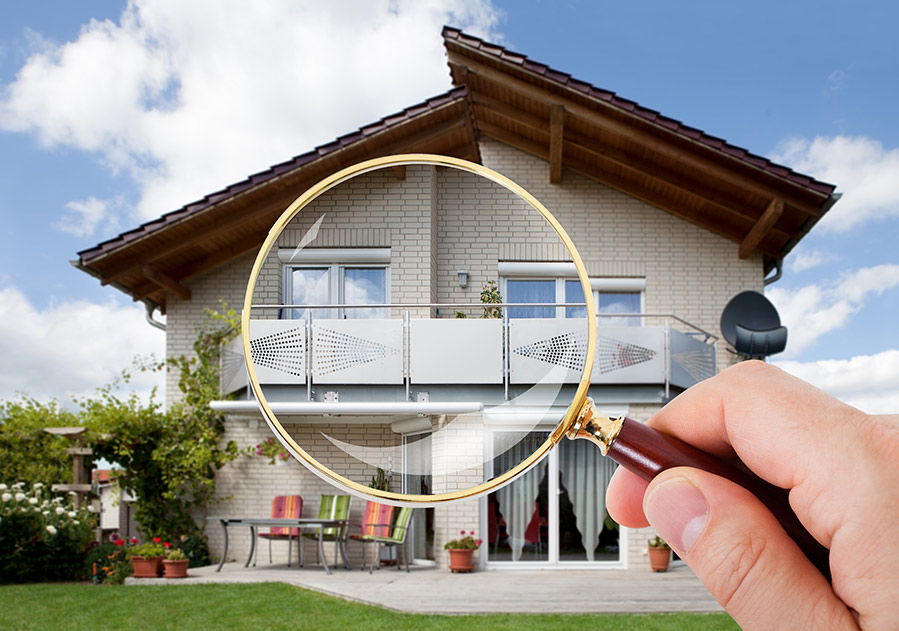Magnifying glass held up to a house